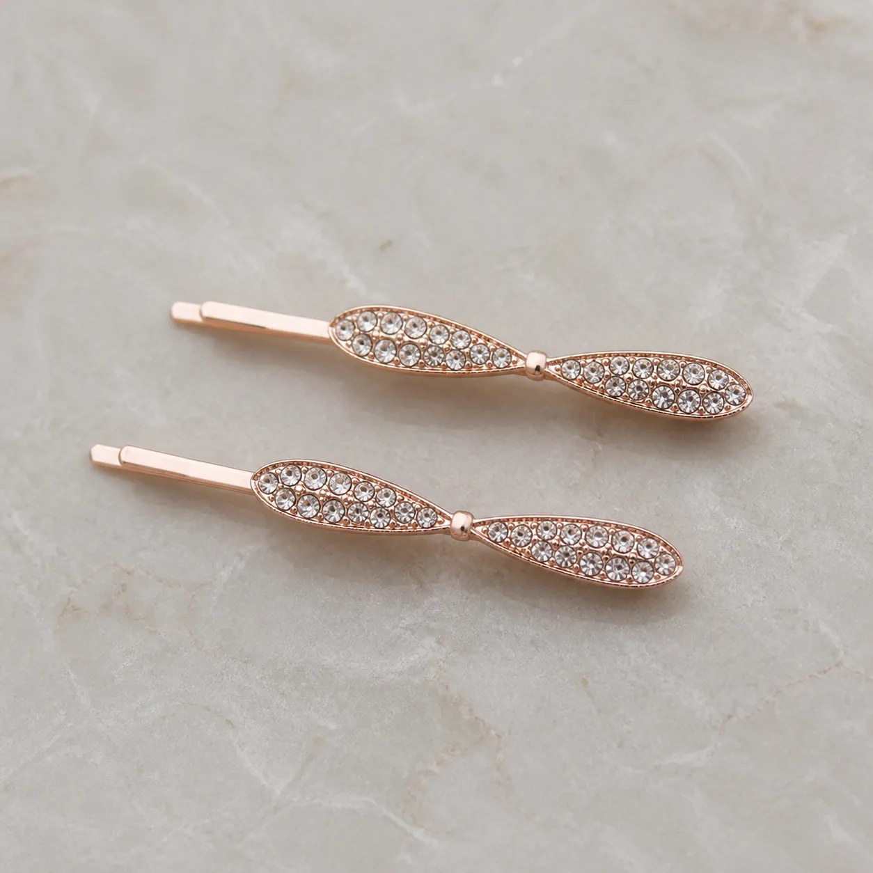 Conjunto de 2 Ganchos Rosa-Dourado com Laço e Strass Ganchos rosa-dourado com laços finos e strass transparente