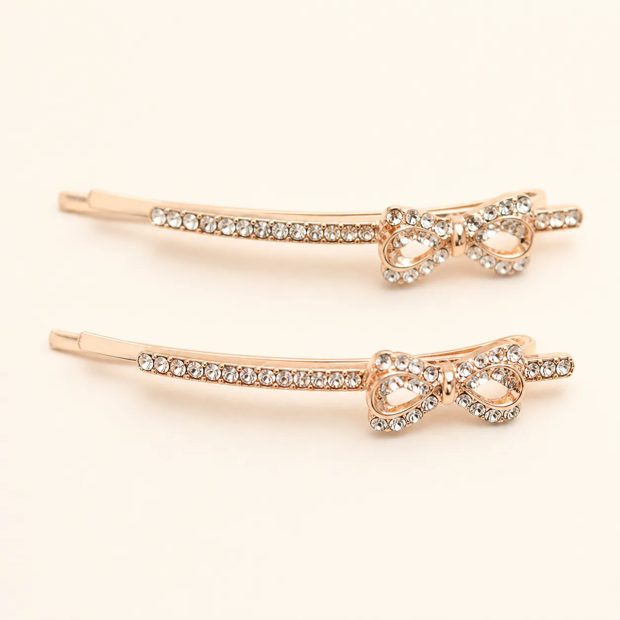 Conjunto de 2 Ganchos Rosa Dourado com Laço de Cristais Conjunto de dois ganchos rosa dourado com laço de cristais