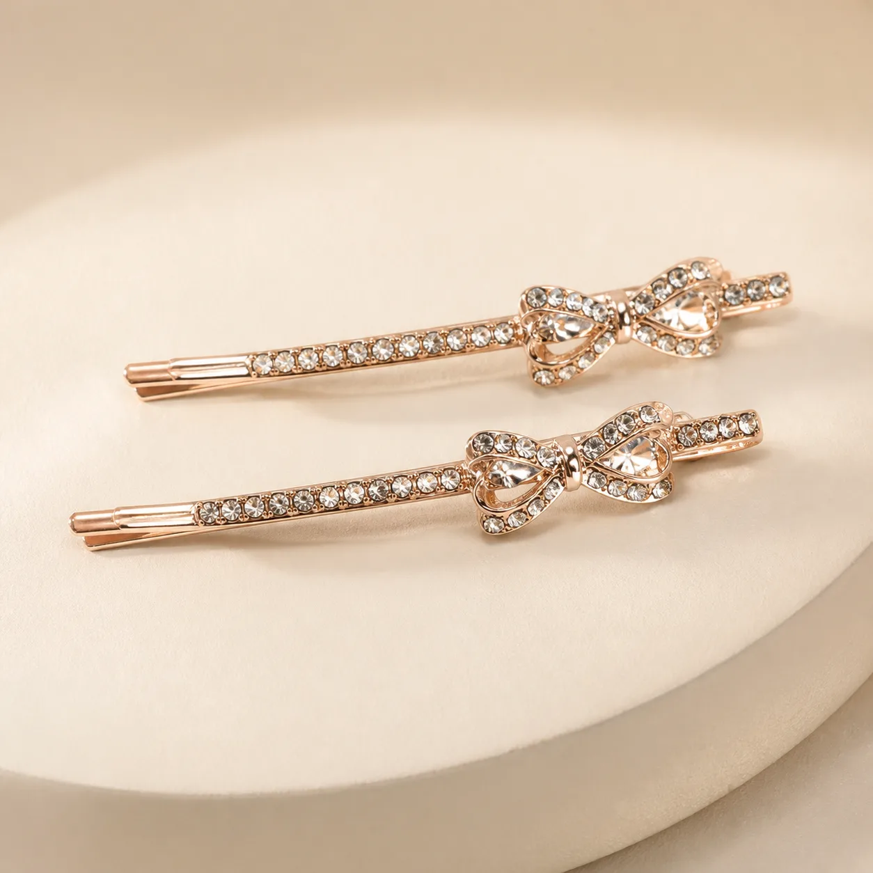 Conjunto de 2 Ganchos Rosa Dourado com Laço de Cristais Dois ganchos rosa dourado com laço brilhante