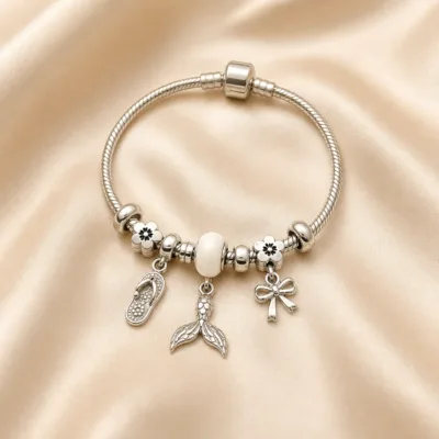 Pulseira prateada com berloques brancos, uma pulseira em cetim bege