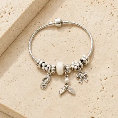 Pulseira prateada com berloques brancos, uma pulseira em pedra quente