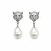 Brincos prateados com cabeças felinas e pérolas em fundo branco