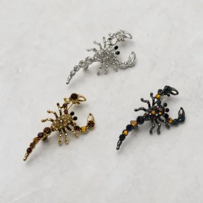 Comparação dos três acabamentos do broche escorpião