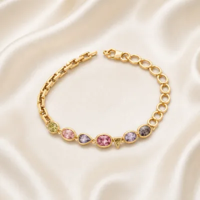 Pulseira dourada cristais 83977-01 modelo D elos assimétricos coloridos sobre cetim marfim