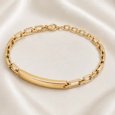 Pulseira dourada geométrica 83978-02, placa linear sobre cetim marfim