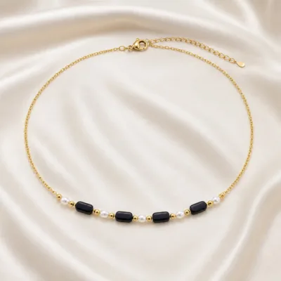 colar dourado preto com pérolas e amuletos, A — Cinco Barras Negras e Pérolas, em cetim marfim, referencia 85182-02