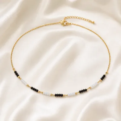 colar dourado preto com pérolas e amuletos, C — Segmentos Preto e Gelo, em cetim marfim, referencia 85182-02