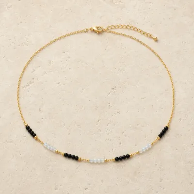 colar dourado preto com pérolas e amuletos, C — Segmentos Preto e Gelo, em pedra clara de tom quente, referencia 85182-02