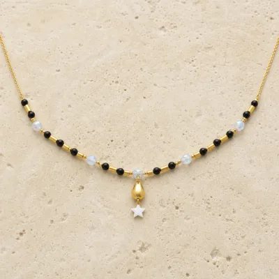 colar dourado preto com pérolas e amuletos, D — Estrela Branca e Gota Dourada, em pedra clara de tom quente, referencia 85182-02