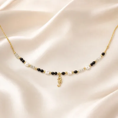 colar dourado preto com pérolas e amuletos, I — Pérolas Quadradas e Cavalo-Marinho, em cetim marfim, referencia 85182-02