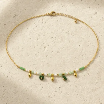 colar dourado verde com pérolas e amuletos, D — Gotas Douradas e Folhagem Verde, em pedra clara de tom quente, referencia 85182-05