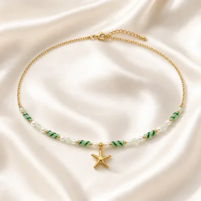 colar dourado verde com pérolas e amuletos, J — Estrela-do-Mar e Contas Listradas, em cetim marfim, referencia 85182-05