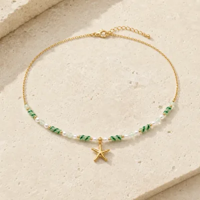 colar dourado verde com pérolas e amuletos, J — Estrela-do-Mar e Contas Listradas, em pedra clara de tom quente, referencia 85182-05