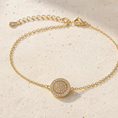 pulseira com medalhão circular dourado em pedra clara de tom quente, referência 85203-05
