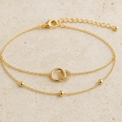 pulseira dupla com elos entrelaçados dourado em pedra clara de tom quente, referência 85203-08