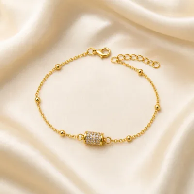 pulseira com cilindro pavé de cristais dourado em cetim marfim, referência 85204-25