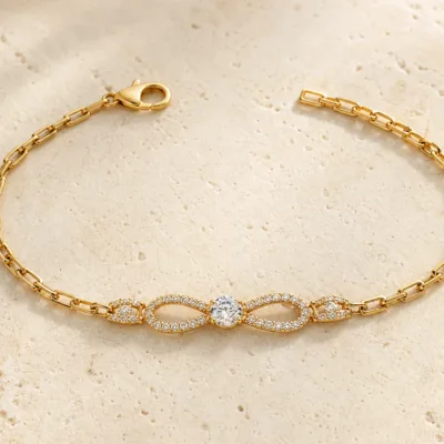 pulseira dourada laço infinito com cristal em pedra clara de tom quente, referencia 85250-01