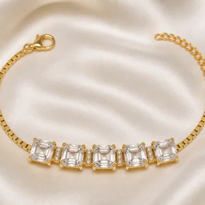 pulseira dourada com cinco cristais quadrados em cetim marfim, referencia 85251-01