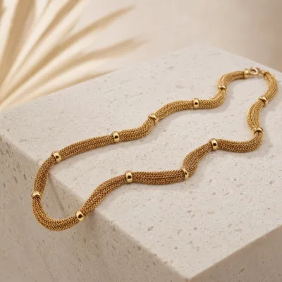 Colar dourado multicorrentes apresentado sobre pedra clara