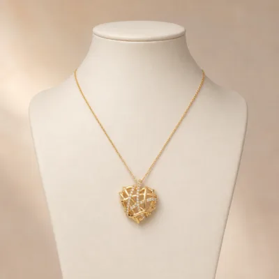 Colar dourado com coração entrelaçado apresentado em expositor