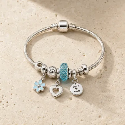 Pulseira prateada com berloques azuis e coracao - pedra quente