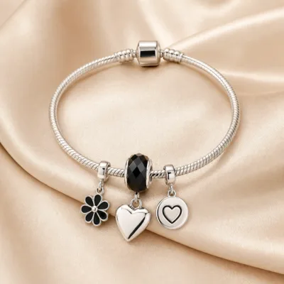 Pulseira prateada com berloques pretos e coracao - cetim bege