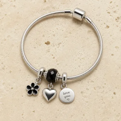 Pulseira prateada com berloques pretos e coracao - pedra quente