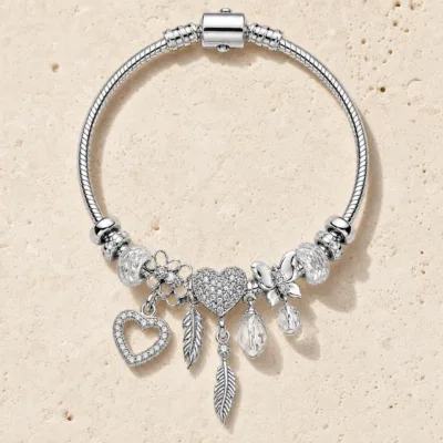 pulseira prateada transparente com coração em pedra clara de tom quente, referencia 85327-3