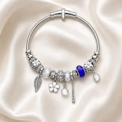 pulseira prateada transparente com conta azul em cetim marfim, referencia 85327-4