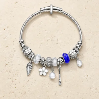 pulseira prateada transparente com conta azul em pedra clara de tom quente, referencia 85327-4