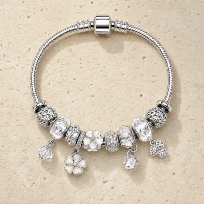 pulseira prateada transparente com flores em pedra clara de tom quente, referencia 85327-5