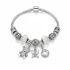 pulseira prateada com urso e borboleta em fundo branco, referencia 85327-6