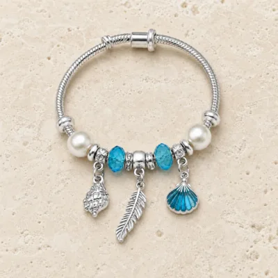 pulseira prateada azul com conchas em pedra clara de tom quente, referencia 85328-1
