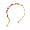 pulseira vermelha dourada com pérola em fundo branco, referência 85381-1
