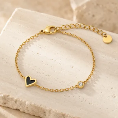 pulseira dourada com coração preto e cristal em pedra clara de tom quente, referência 85382-3