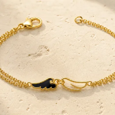 pulseira dourada com asas pretas em pedra clara de tom quente, referência 85383-2