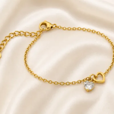 pulseira dourada com coração de cristal em cetim marfim, referência 85383-3