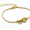 pulseira dourada com borboleta, contas e cristal em fundo branco, referência 85383-4