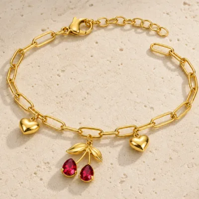 pulseira dourada com cerejas vermelhas e corações em pedra clara de tom quente, referência 85384-3