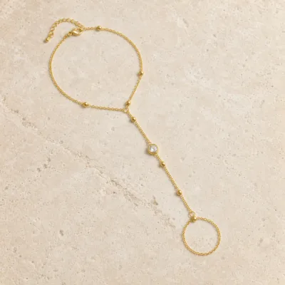 pulseira de mão dourada com cristal e anel em pedra clara de tom quente, referência 85384-6