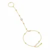 pulseira de mão dourada com cristal e anel em fundo branco, referência 85384-6