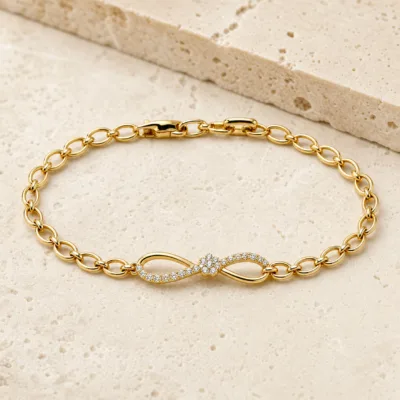 pulseira dourada infinito com zircões em pedra clara de tom quente, referencia 85401-2