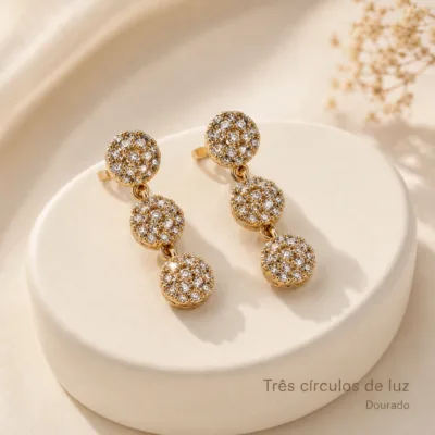 Detalhe dos brincos de três círculos dourados
