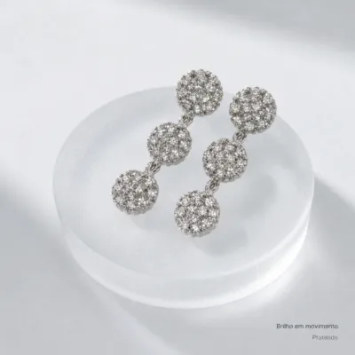Detalhe dos brincos de três círculos prateados