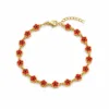 Pulseira dourada de flores vermelhas com centros pretos, uma pulseira, vista em fundo branco