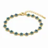 Pulseira dourada de flores azuis com centros pretos, uma pulseira, vista em fundo branco
