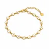 Pulseira dourada de flores brancas, uma pulseira em fundo branco