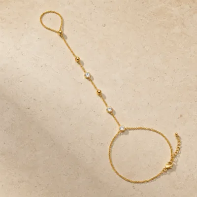 pulseira de mão dourada com cristais e contas em pedra clara de tom quente, referência 85474-2