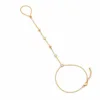 pulseira de mão dourada com cristais e contas em fundo branco, referência 85474-2
