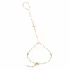 pulseira de mão dourada com cruz e três cristais em fundo branco, referência 85475-2